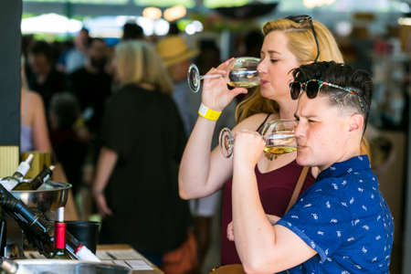 Johannesburg, South Africa - October 15 2016: A young couple drinking, eating and generally enjoying a day out at a Food and Wine Fair drinking and generally enjoying a day out at a Food and Wine Fairのeditorial素材