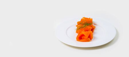 Slices of folded Salmon on a white plate on a white backgroundの写真素材