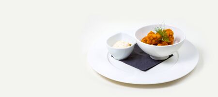 Cheese Poppers and dip in a white bowl on a white plate on a white background isolatedの写真素材