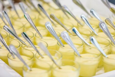 Small glasses of custard pudding dessert for catering at gala dinner banquet eventの写真素材
