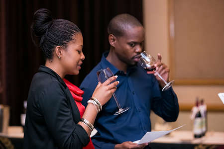 Johannesburg, South Africa - May 10 2013: Sophisticated people sampling wine at a wine tasting event