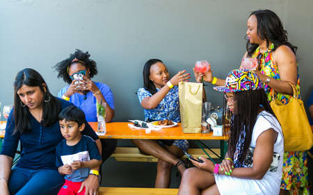 Johannesburg, South Africa - October 15 2016: Diverse Friends eating, drinking and generally...