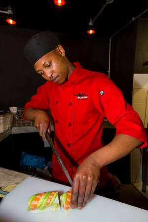 Johannesburg, South Africa - September 28 2014: Chef  preparing a fresh roll of Sushiのeditorial素材