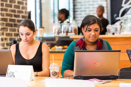 Johannesburg, South Africa - October 03 2013: Diverse Female Customers using Internet in a Coffee Shopのeditorial素材
