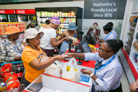 Soweto, South Africa - December 1, 2016: African cashier and customer at checkout at local Pick n...