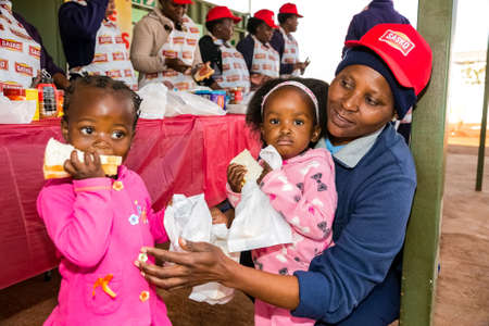 Soweto, South Africa - July 18, 2016: Young African Preschool kids eating sandwiches in the playground of a kindergarten schoolのeditorial素材
