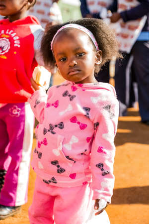 Soweto, South Africa - July 18, 2016: Young African Preschool kids eating sandwiches in the playground of a kindergarten schoolのeditorial素材