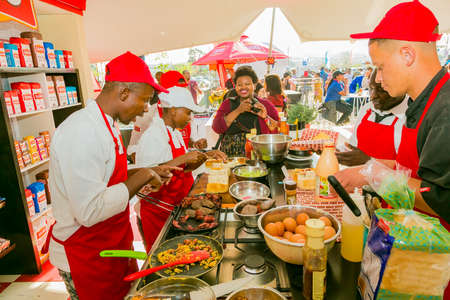 Soweto, South Africa - September 8, 2018: Diverse African vendors cooking and serving various bread based street food at outdoor festivalのeditorial素材