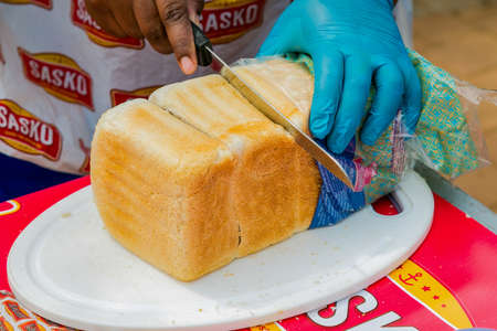 Soweto, South Africa - September 17, 2017: Diverse African vendors cooking and serving various bread...