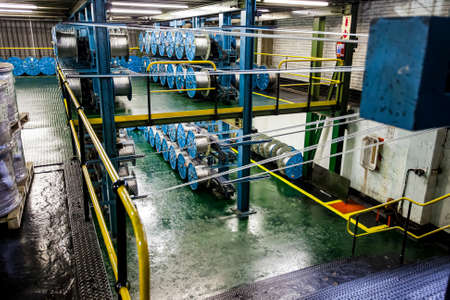 Johannesburg, South Africa - October 16, 2012: Wide angle view of spools of cable on a large machine in a conveyor belt factoryのeditorial素材