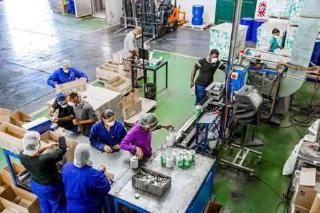 Johannesburg, South Africa - October 19, 2012: Diverse people working on an assembly line in a glue...
