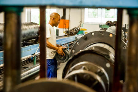 Johannesburg, South Africa - October 19, 2012: Diverse workers inside a rubber and pipe fabrication...