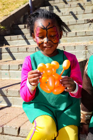 Soweto, South Africa - July 18, 2012: Young African Preschool children playing with animal balloons on the playgroundのeditorial素材