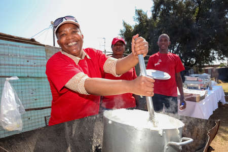 Soweto, South Africa - September 10, 2011: African Woman cooking Mielie Pap maize porridge on side street in urban Sowetoのeditorial素材