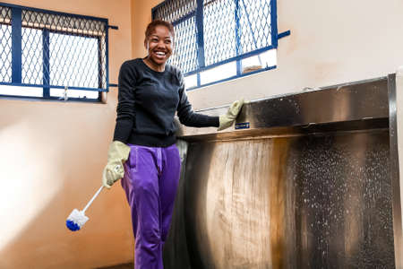 Soweto, South Africa - July 21, 2012: Diverse Women performing community service volunteer cleaning...