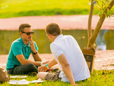 Johannesburg, South Africa, 05/09/2015,  Gay couple lying on the grass at The Winter Sculpture Fair at Nirox Sculpture Parkのeditorial素材