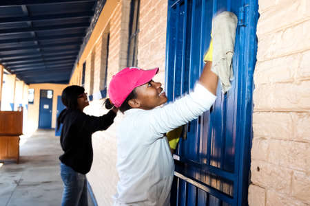 Soweto, South Africa - July 21, 2012: African Women performing community service volunteer cleaning work at township schoolのeditorial素材