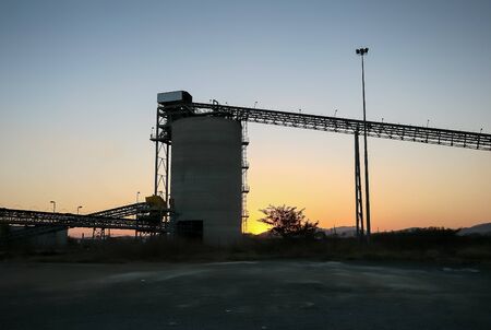 Silhouette of a mining silo and conveyor belts on a Platinum Mine