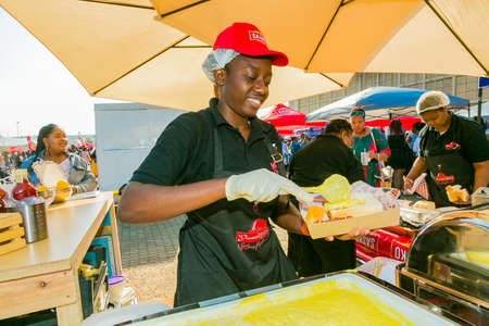 Soweto, South Africa - September 8, 2018: Diverse African vendors cooking and serving various bread based street food at outdoor festivalのeditorial素材