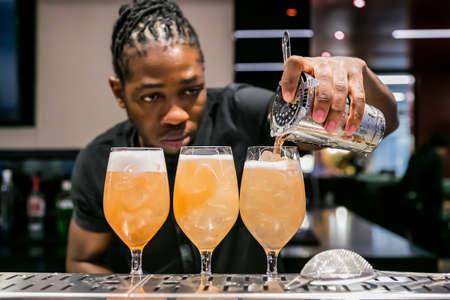 Johannesburg, South Africa - November 15, 2017: African Bartender pouring a Fruity cocktail at bar counterのeditorial素材