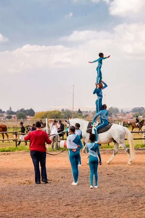 Soweto, South Africa - April 16, 2012: Young African children performing acrobatics on horse backのeditorial素材