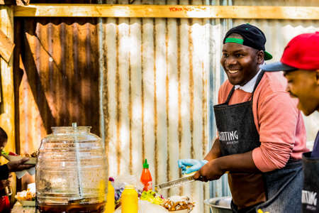 Johannesburg, South Africa - May 24, 2015: African Male vendor working at take out food at outdoor stall at farmer's marketのeditorial素材