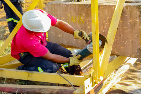 Johannesburg, South Africa - June 06 2010: Tradesman working with an angle grinder on a building siteのeditorial素材