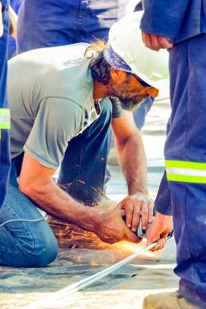 Johannesburg, South Africa - June 07 2010: Tradesman working with an angle grinder on a building siteのeditorial素材