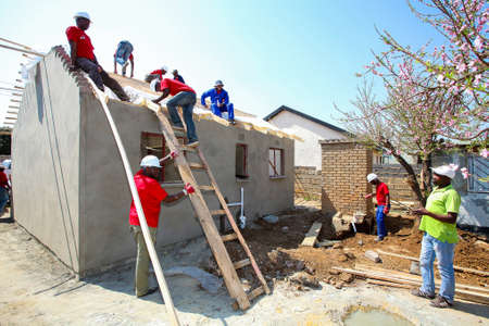 Soweto, South Africa, September 10, 2011,  Diverse Community members building a low cost house as a team in Sowetoのeditorial素材