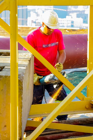 Johannesburg, South Africa - June 06 2010: Tradesman working with an angle grinder on a building siteのeditorial素材