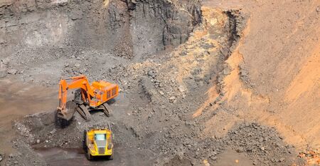 Manganese Mining and Excavator digging and loading ore rocks on a Manganese mine