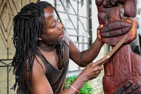 Johannesburg, South Africa - January 17, 2011: African Man sculptor carving a traditional statue out of woodのeditorial素材