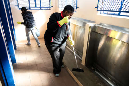 Soweto, South Africa - July 21, 2012: Diverse Women performing community service volunteer cleaning work at township schoolのeditorial素材