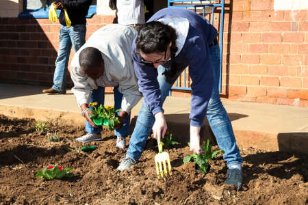 Soweto, South Africa - July 21, 2012: Diverse People performing Community Service gardening at local township schoolのeditorial素材