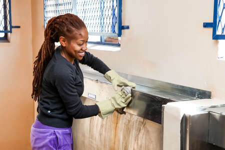 Soweto, South Africa - July 21, 2012: Diverse Women performing community service volunteer cleaning work at township schoolのeditorial素材