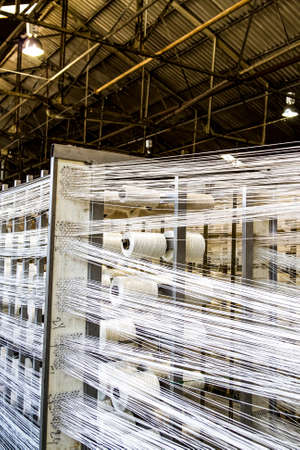 Johannesburg, South Africa - October 16, 2012: Cotton Thread Bobin on a copwinder weft assembly line loomのeditorial素材