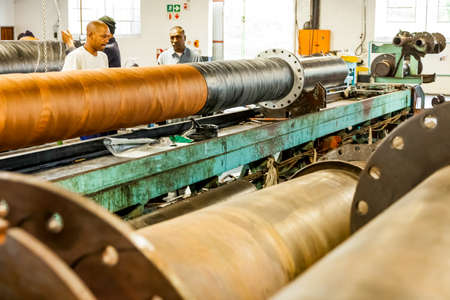 Johannesburg, South Africa - October 19, 2012: Diverse workers inside a rubber and pipe fabrication assembly line in a factoryのeditorial素材