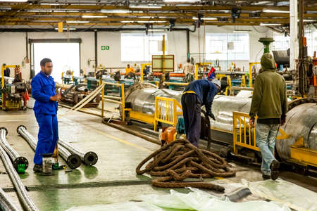 Johannesburg, South Africa - October 19, 2012: Diverse workers inside a rubber and pipe fabrication assembly line in a factoryのeditorial素材