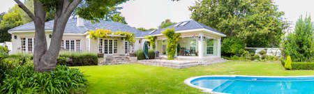 Wide angle view of Exterior of Upmarket wealthy suburban mansion house with landscaped garden and swimming poolのeditorial素材