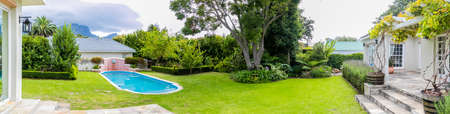 Wide angle view of Exterior of Upmarket wealthy suburban mansion house with landscaped garden and swimming poolのeditorial素材