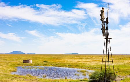 Windmill Windpump on a farm in rural grassland area of South Africaの写真素材
