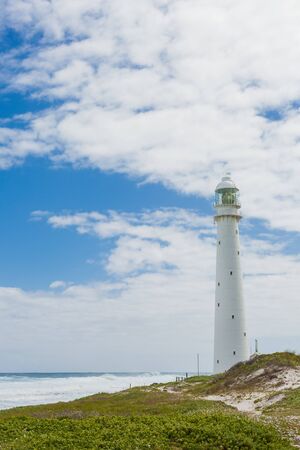 Lighthouse on a rugged coastline during the daytime. Photographed in Cape Town South Africa on the West coast side of the peninsulaの写真素材