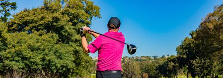 Man teeing off on a golf course Tee with a driver clubの写真素材