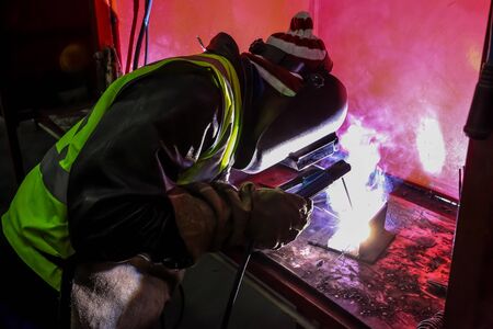 Man welding metal in a workshop, Tradesman working with welding torch