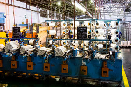 Johannesburg, South Africa - October 16, 2012: Cotton Thread Bobin on a copwinder weft assembly line...