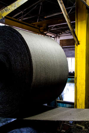 Johannesburg, South Africa - October 16, 2012: Close up of a roll of rubber on a machine in a conveyor belt factoryのeditorial素材