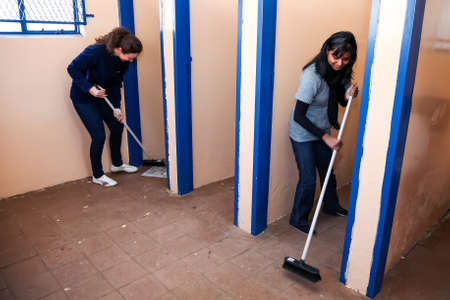 Soweto, South Africa - July 21, 2012: Diverse Women performing community service volunteer cleaning work at township schoolのeditorial素材