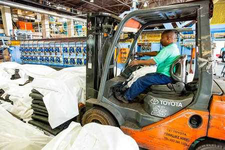 Johannesburg, South Africa - October 19, 2012: African man operating a fork-lift vehicle in a rubber...
