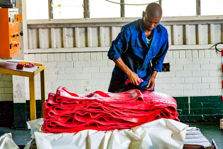 Johannesburg, South Africa - October 19, 2012: Diverse people working on an assembly line in a rubber factoryのeditorial素材