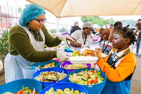 Johannesburg, South Africa - March 24, 2018: Soup Kitchen community outreach catering staff dishing up meals for African childrenのeditorial素材